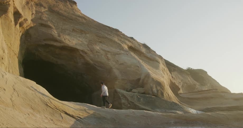 A man walks into a desert cave