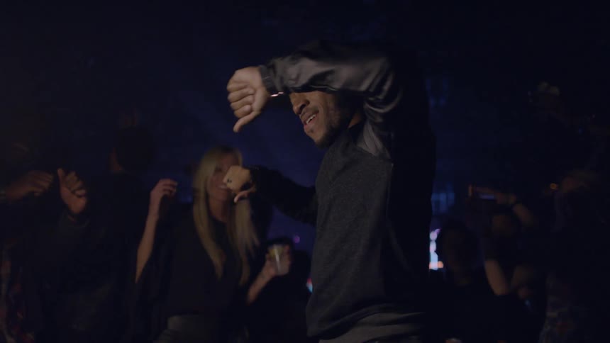 Man in a baseball cap as others dance around him