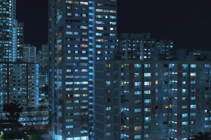 Lights turn on in metropolitan city apartments at night