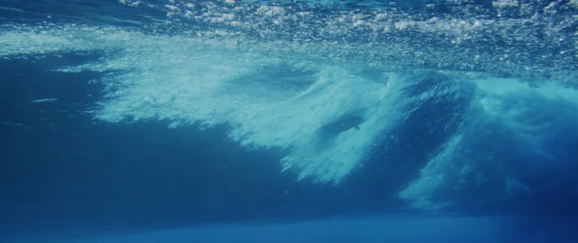 View from inside the sea with a surfboard riding a wave