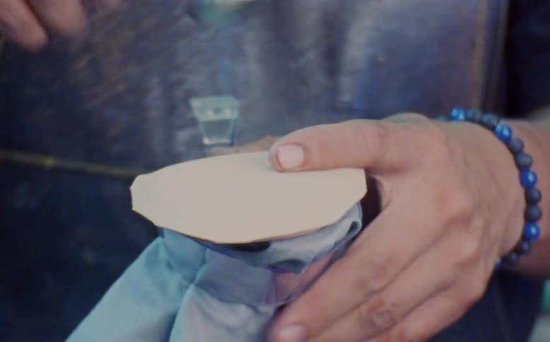 Closeup of a human hand performing manufacturing work with a hammer