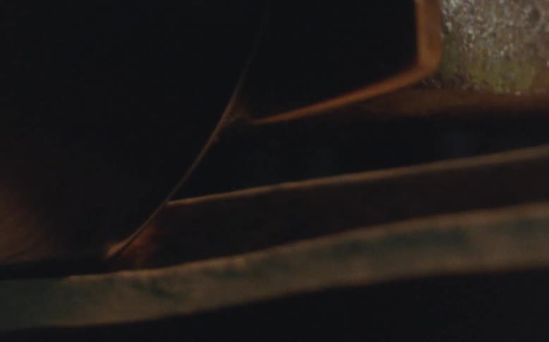 Close up of a wheel shaping a strip of leather