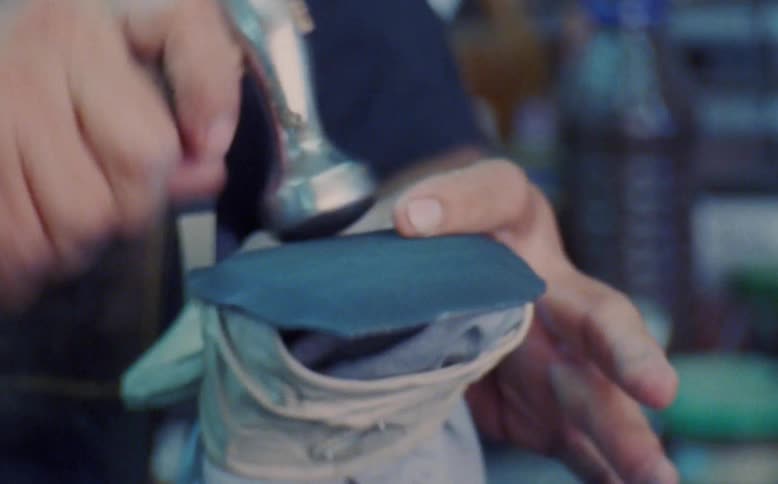 Human hand hammering a high heel in manufacturing production