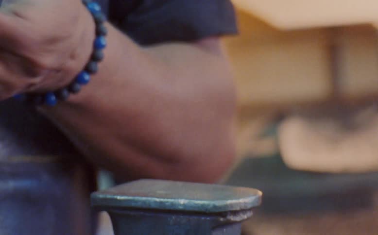 A man hammering the sole of a womans shoe