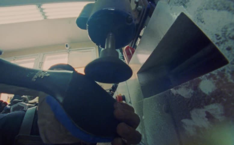 Man passing a high heel through a machine finalizing the manufacturing process