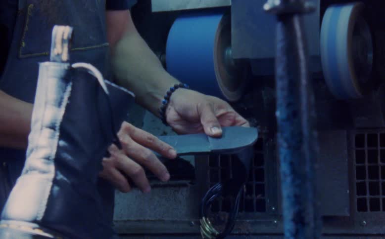Hand of a man inspecting the sole of a womens shoe