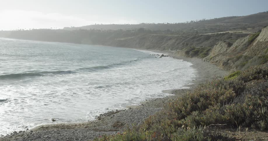 Ocean waves wash ashore a pebbly beach