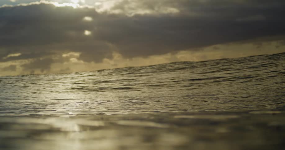 Ocean swells flow across surface of water on a cloudy day
