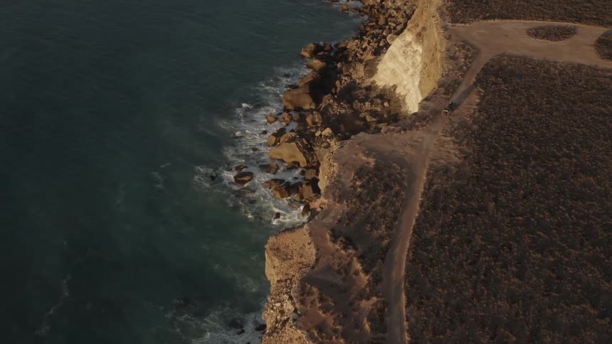 Aerial of wave crashing on a cliff in the coast