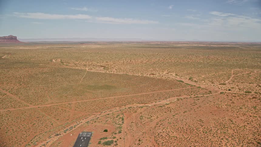 Flying over Monument Valley Airport in Utah this stunning aerial footage captures the wide desert valley and dramatic landscape as the plane approaches the runway