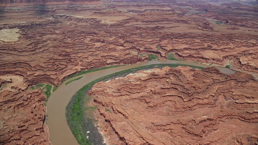 Aerial footage flying over the Colorado River approaching canyons in Canyonlands National Park Utah showcasing the natural beauty and breathtaking landscape of the Southwest United States