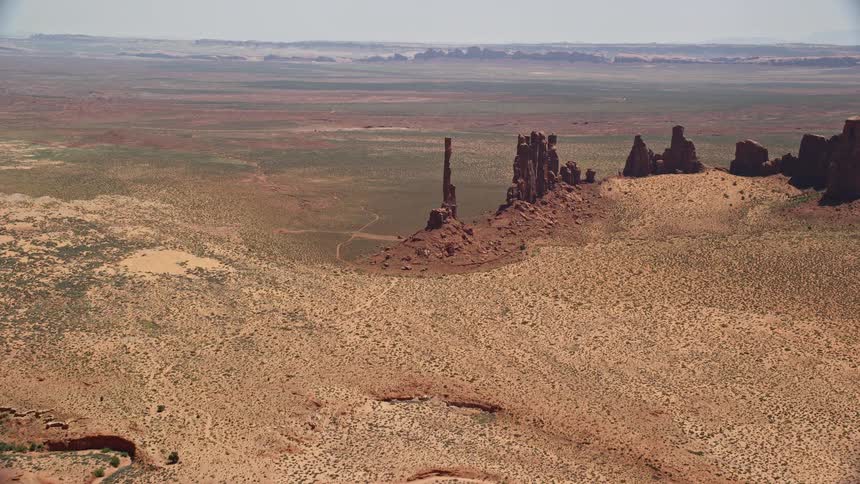 Approaching Totem Pole Butte and Yei Bi Chei Butte witness the majestic beauty of Monument Valley's desert landscape on a sunny day in Utah and Arizona