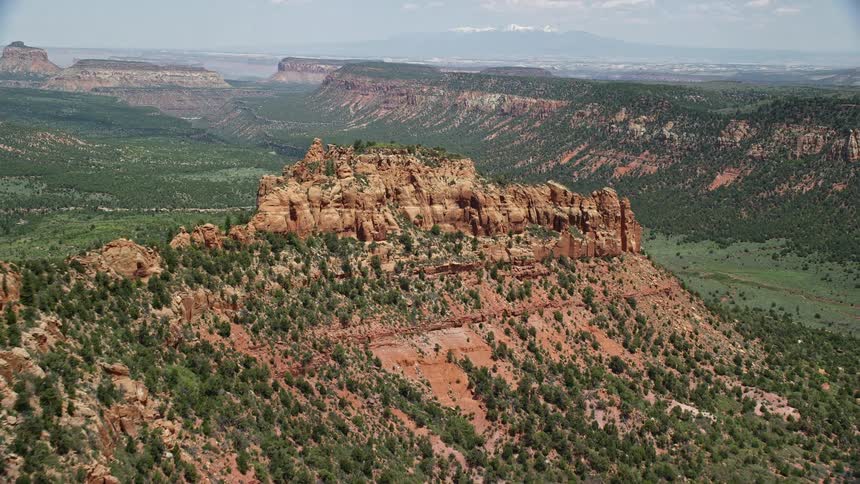 Approaching a mesa with trees and a butte in Manti-La Sal National Forest Utah inaerial footage