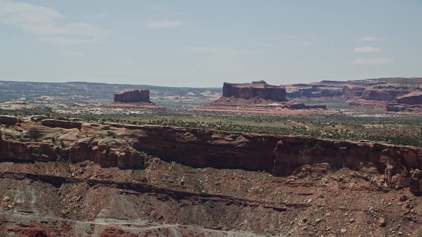 an aerial view of the Monitor Butte and Merrimac Butte in Moab Utah with stunning desert landscapes and rock formations