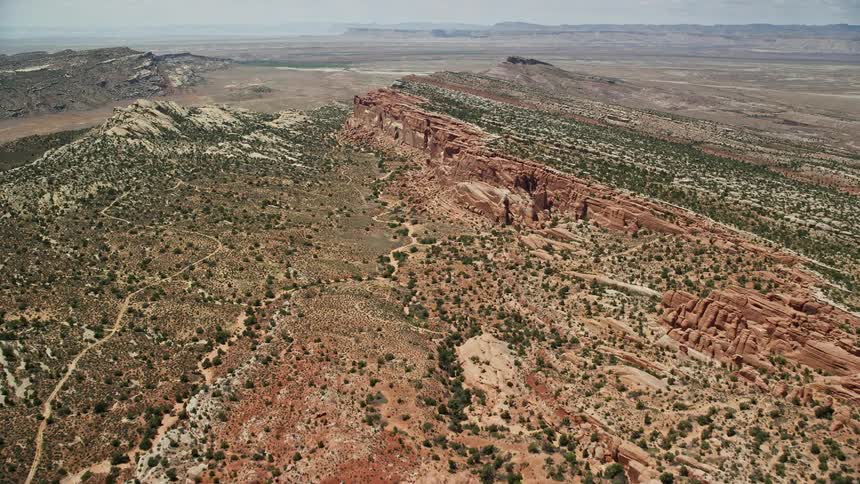 Aerial footage flying over rock fins and vegetation in Eagle Park Arches National Park Utah showcasing the natural beauty of the desert landscape during daytime in the Southwest United States