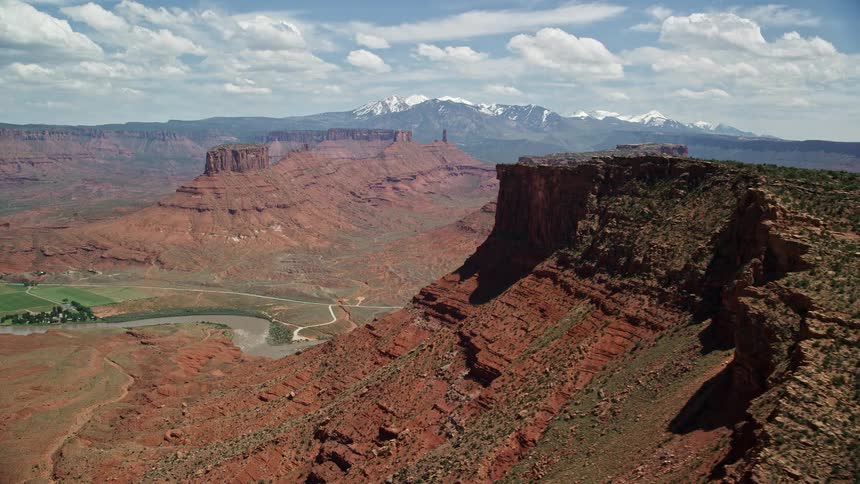 A sweeping aerial view of the Colorado River winding through the stunning badlands of Dry Mesa in Moab Utah showcasing the majestic buttes and rugged desert landscape