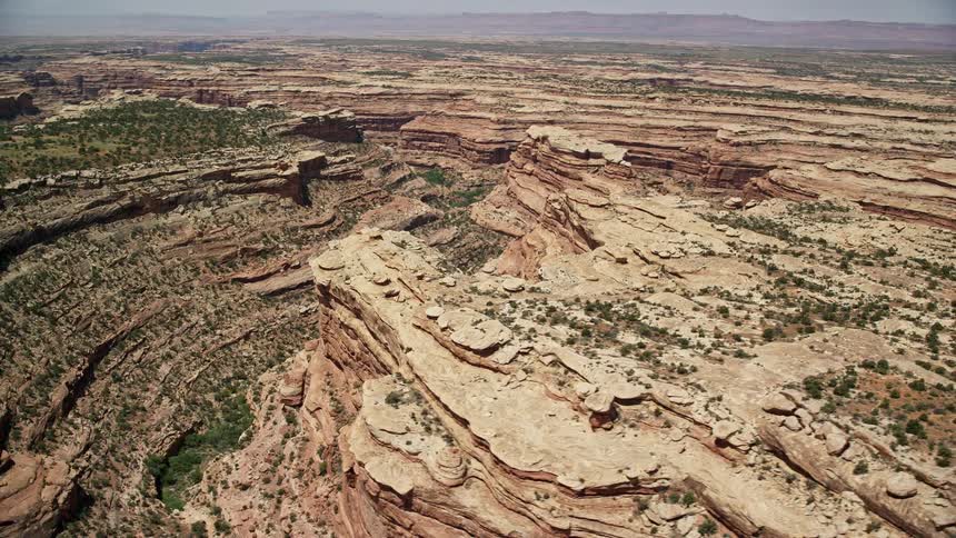  aerial footage of steep-sided canyons with mesa-topped desert vegetation in Cedar Mesa Utah showcasing the stunning desert landscape of the Southwest United States