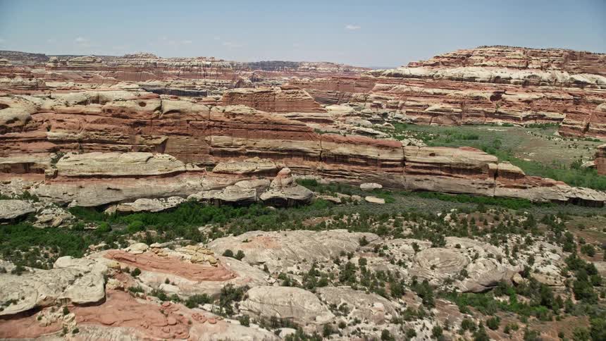  aerial footage showcasing the stunning narrow valley and rock formations of Canyonlands National Park in Utah during a sunny day capturing the arid and famous desert landscape of the Southwest United States