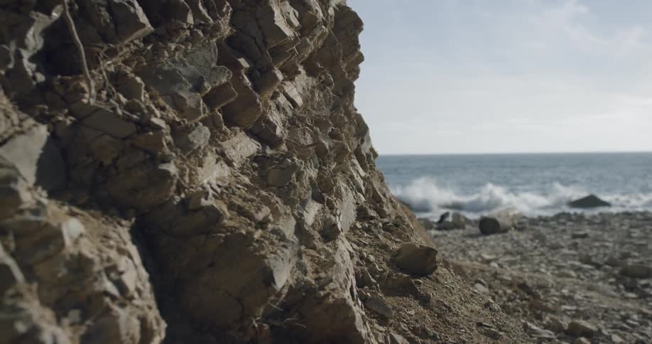 The waves are crashing against the rocks of the shore