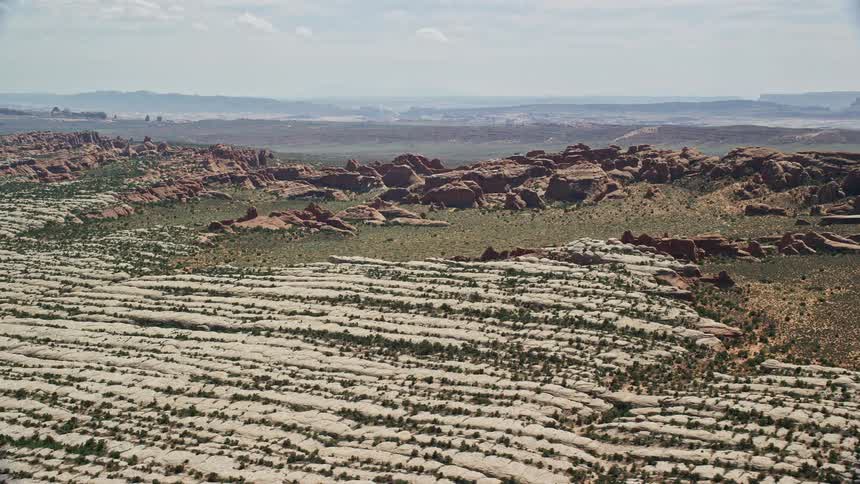 Aerial footage showcasing the stunning rock formations and desert plants of Devil's Garden in Arches National Park Utah on a sunny day during summer