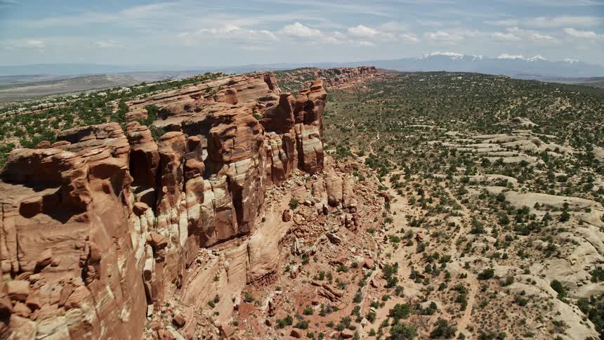 Aerial footage showcasing stunning rock formations in Eagle Park Arches National Park Utah as the drone approaches the striking cliffside formations during a sunny day in the wilderness