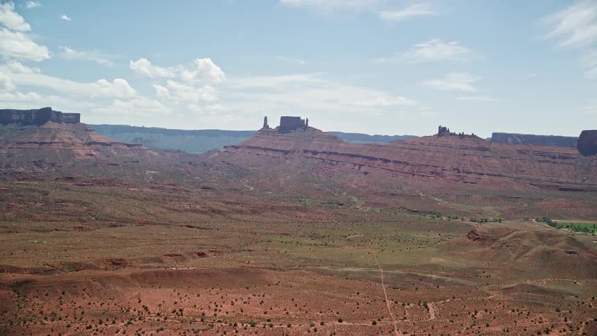  aerial footage showcasing the breathtaking view of distant desert buttes in Moab Utah during a sunny day in the Southwest United States