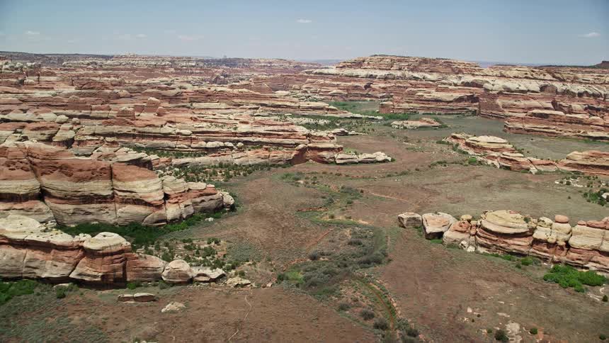 an aerial view of a narrow valley and stunning rock formations in Canyonlands National Park Utah showcasing the captivating beauty of the desert landscape