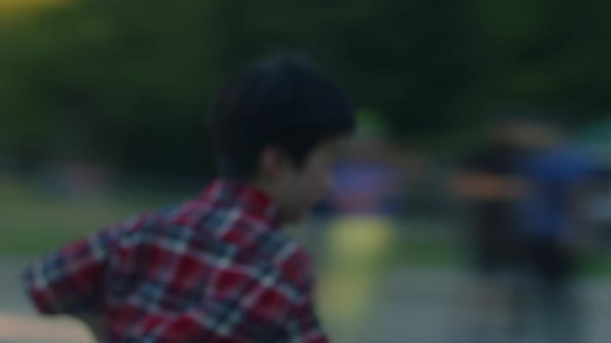 Student with plaid shirt and shorts plays with schoolmates running and having fun