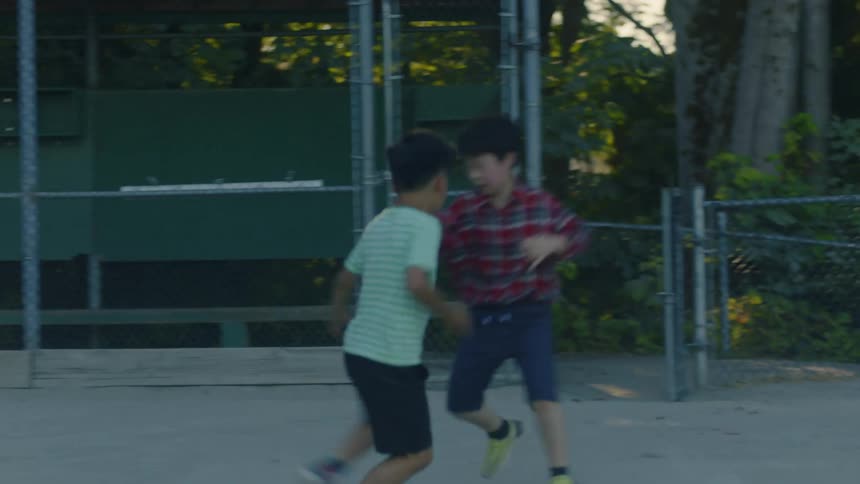 Boys run and chase each other playing tag