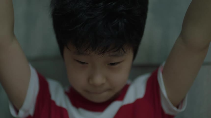 Asian boy looking sadly at a broken plate on the floor