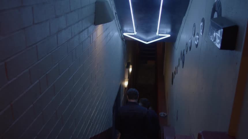 People walking down the stairs of a narrow hallway