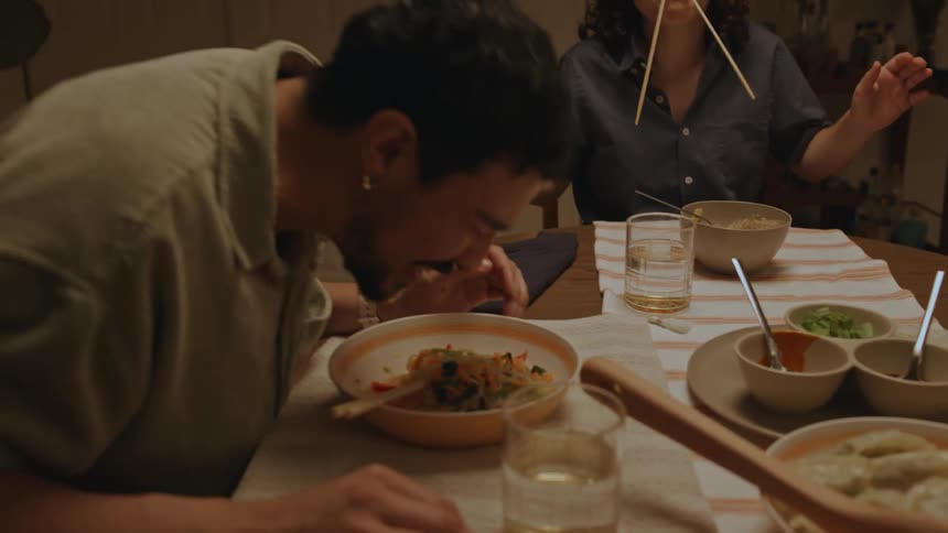 Friends are having fun making funny faces at the dinner table