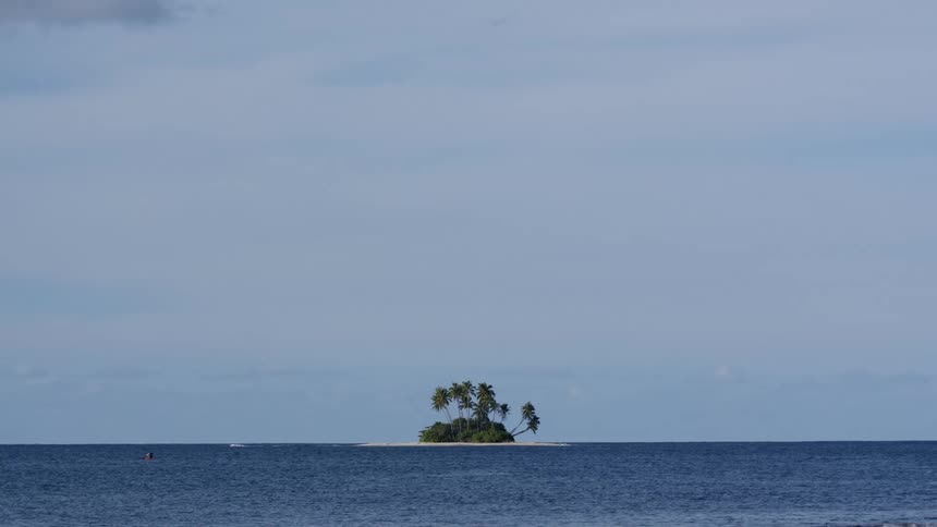 Landscape of the moving sea with an island on the horizon in the background