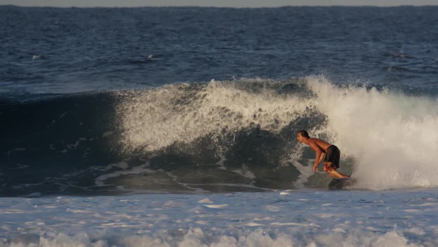 A man surfs a wave in the sea