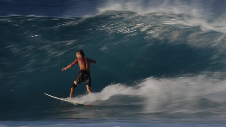 Man surfing waves inside and performing radical maneuvers