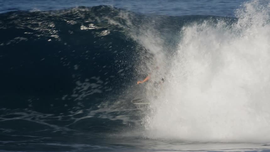 A man surfs on a black surfboard