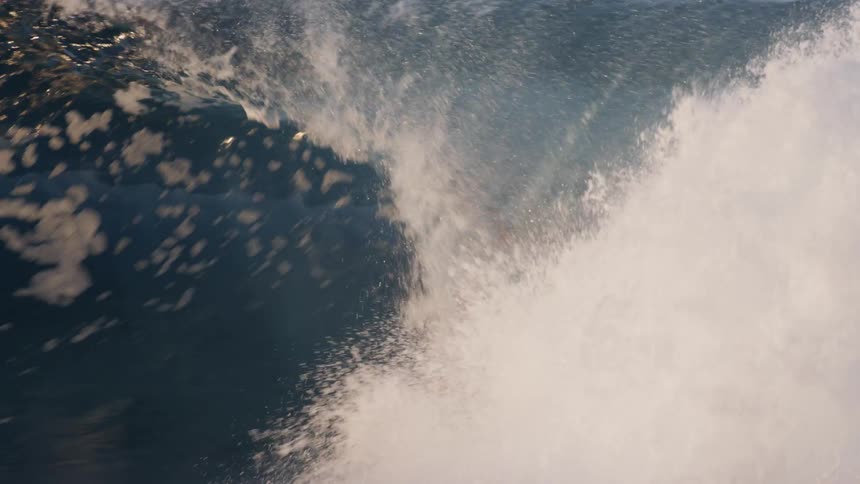 Man surfing waves with maneuvers with boats in the background