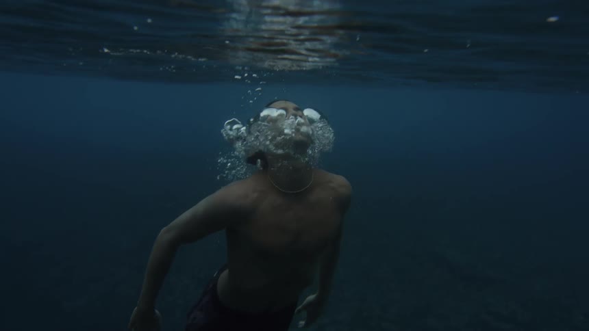 Young man underwater returning to the surface