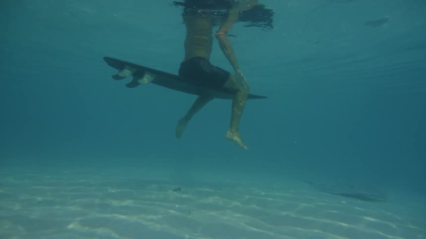 A man is floating in the water on his surfboard