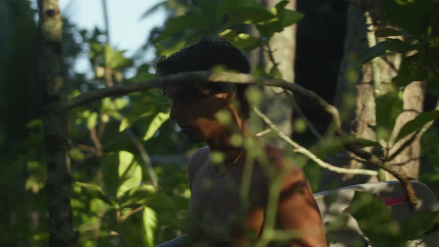 A young man walking thoughtfully through the woods