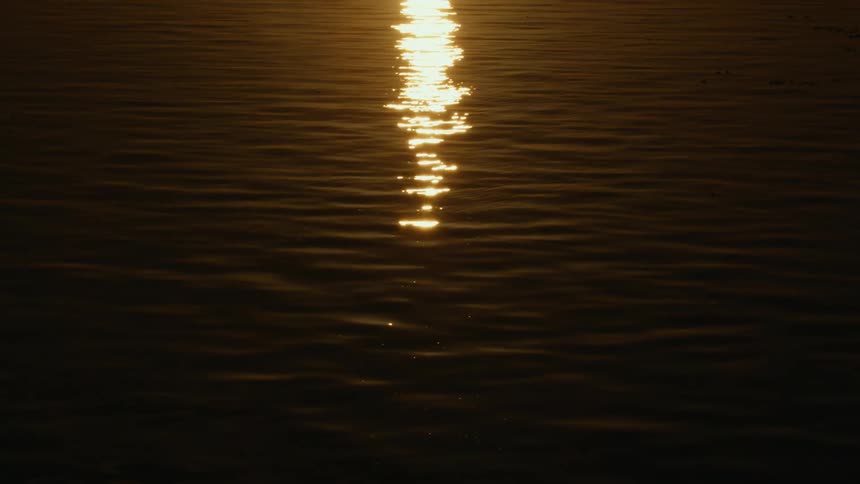 The sun is setting on the ocean