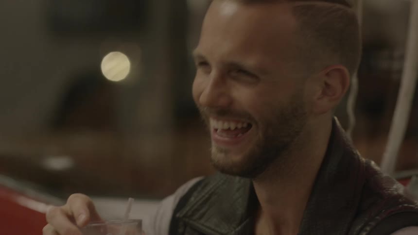 Man laughs holding a drink