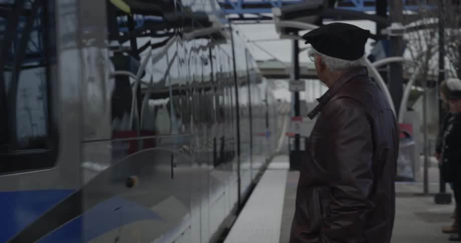Elderly man waits for a train to arrive