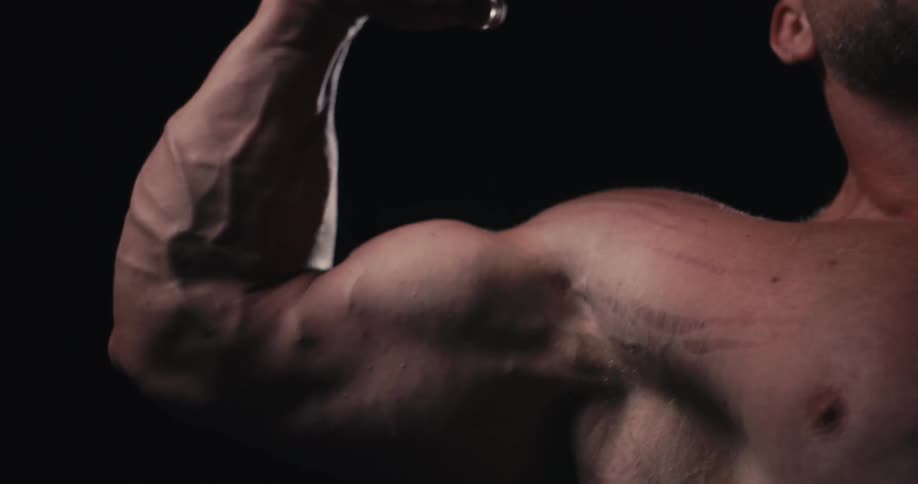 A mans arm is raised as his muscle bulges