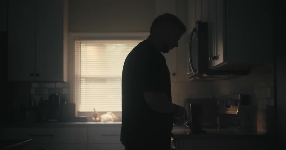 Man putting powder into his shaker bottle in a kitchen
