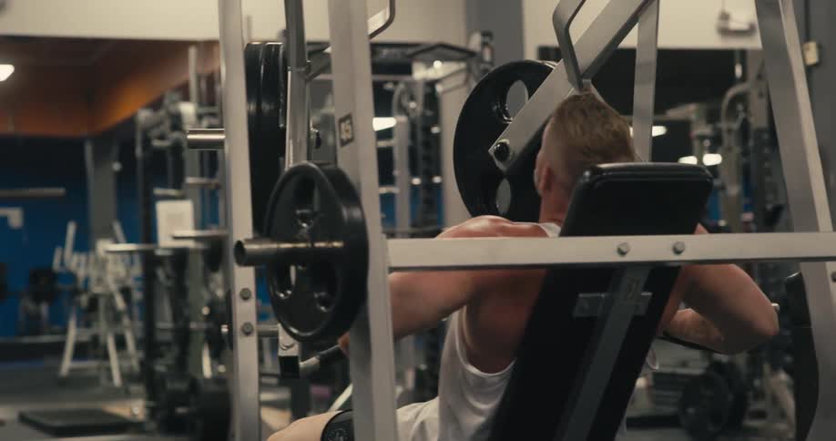 Man in a gym lifting weight in a sitting position