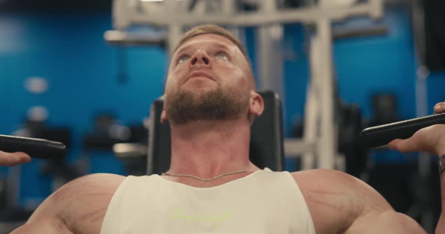 Man lifting weights on a machine in a gym