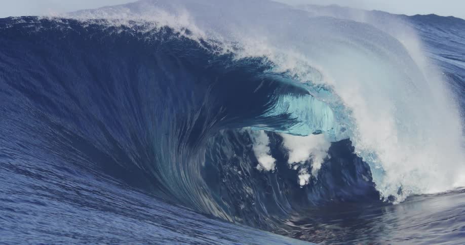 Ocean waves crashing and rolling onto the waters surface in the middle of the day