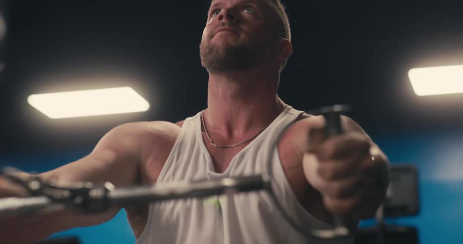 A man working out in a gym doing cardio on a machine