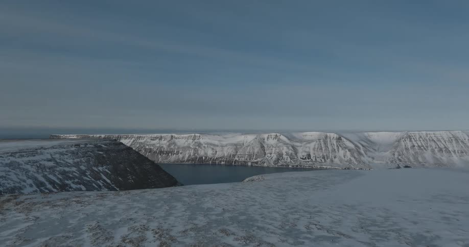 Frozen mountain cliffs and waterway during the day